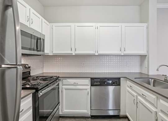 A kitchen with white cabinets and stainless steel appliances.