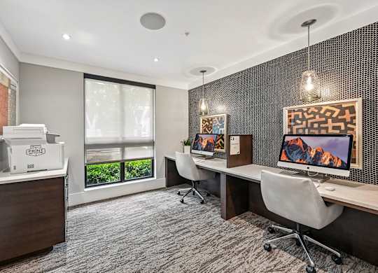A modern office space with a desk, chairs, and a computer monitor.