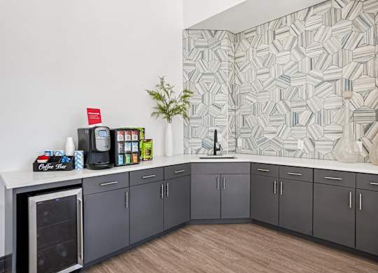 A kitchen with grey cabinets and a white counter top.