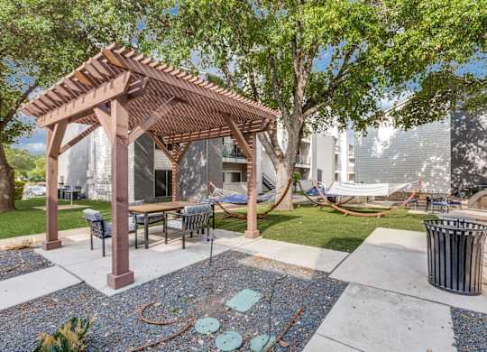 A patio with a table and chairs under a pergola.