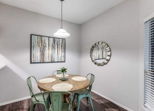 A dining room with a round table and chairs.