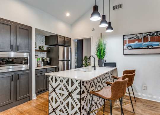 a kitchen with a large center island with a sink and two stools