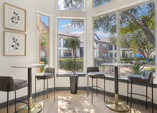 A table with four chairs and two framed pictures on the wall.
