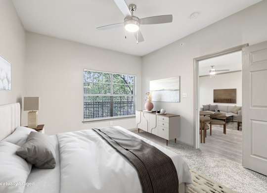A bedroom with a large bed and a ceiling fan.