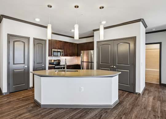 A modern kitchen with a center island and wooden floors.