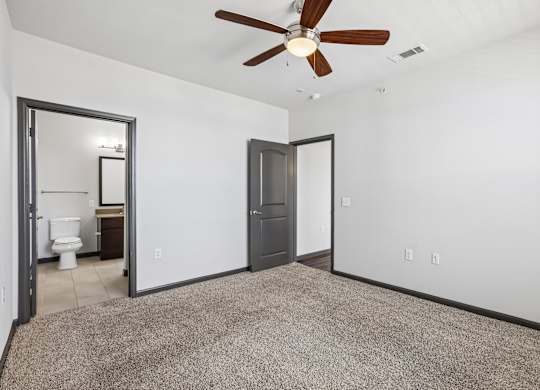 A room with a ceiling fan and a carpeted floor.