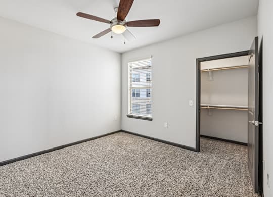 A room with a ceiling fan and a window.