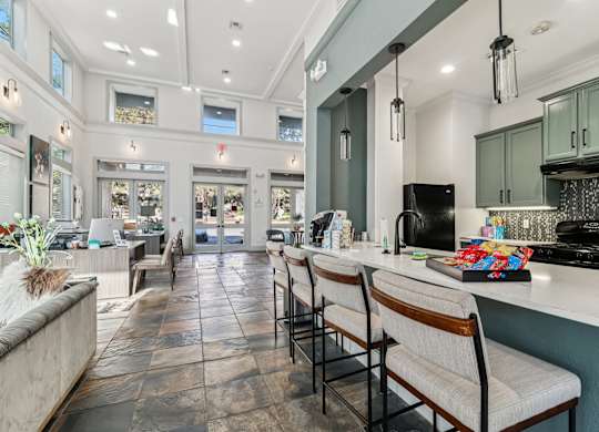 A kitchen with a long counter and chairs.