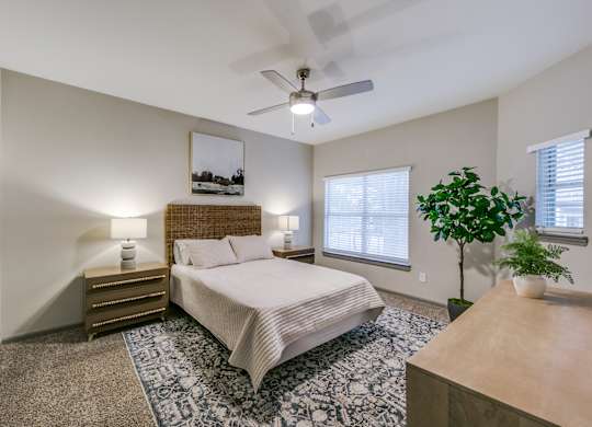 a bedroom with a large bed and a ceiling fan at Canyon Ridge, Austin, 78753