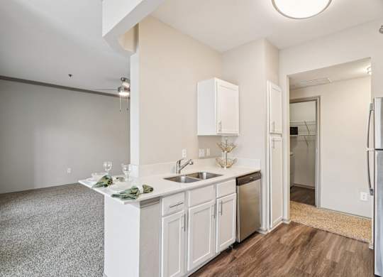 A kitchen with white cabinets and a sink.
