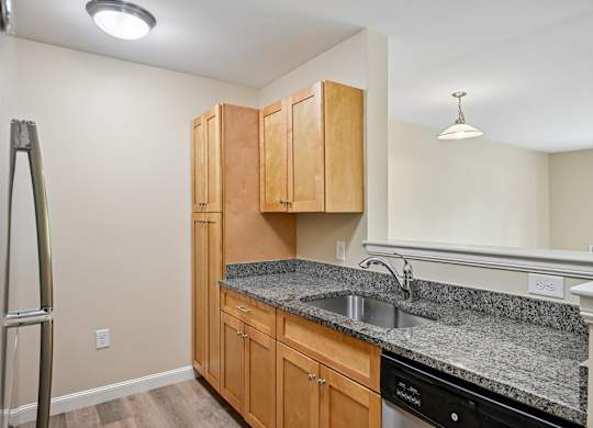 A kitchen with wooden cabinets and granite countertops.