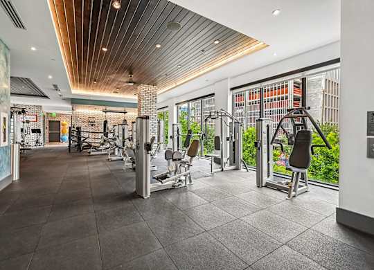 A gym with a variety of equipment including treadmills, weights, and exercise machines.