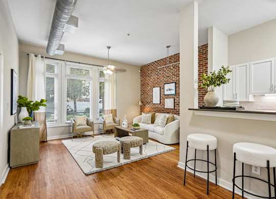 A living room with a white couch and a brick wall.