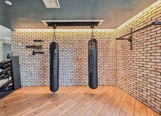 A gym with a brick wall and wooden floor.