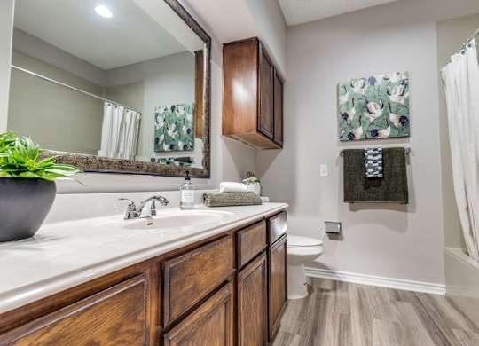 A bathroom with a wooden vanity and a towel hanging on the wall.