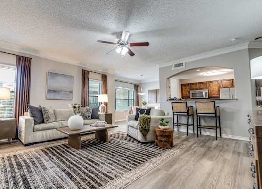 A living room with a couch, chairs, and a coffee table.