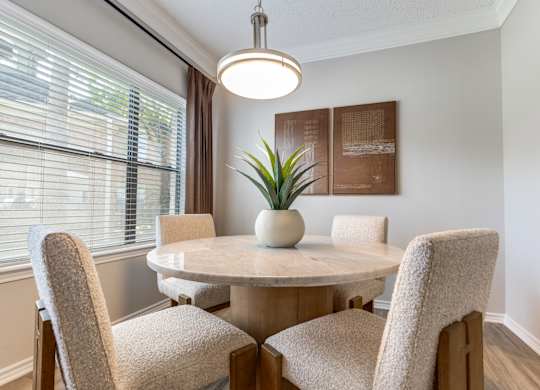 A dining room with a round table and chairs.