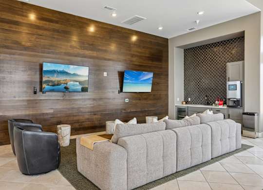 A modern living room with a grey sofa and a wooden wall.