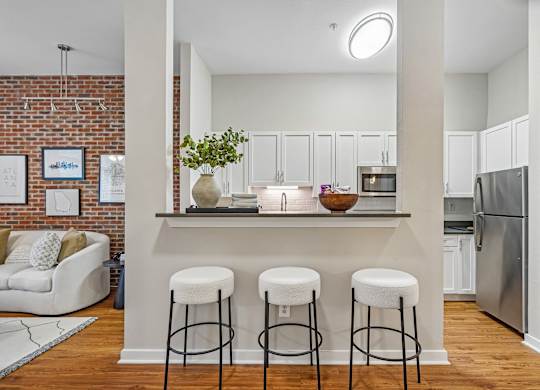 A kitchen with a bar and stools.