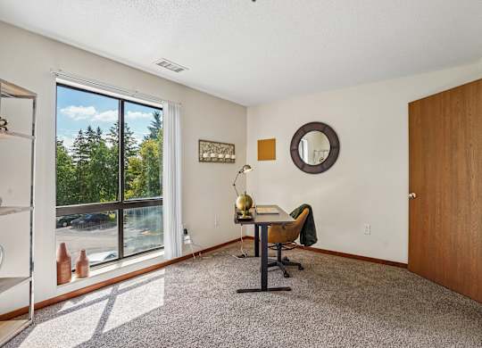 A room with a desk and a chair in it.