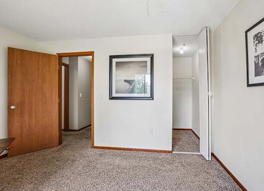 A room with a carpeted floor and a framed picture on the wall.