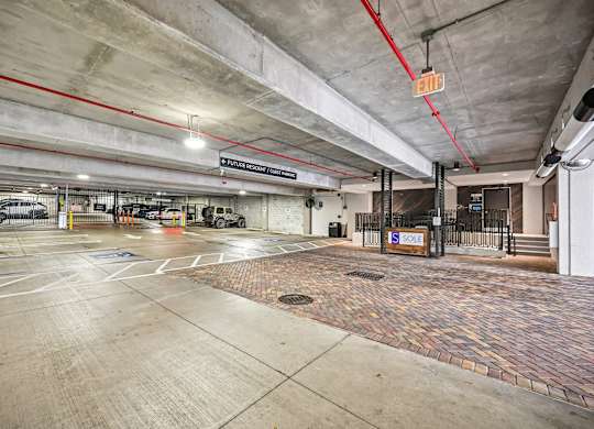 A parking garage with a red line on the ceiling and a sign that says