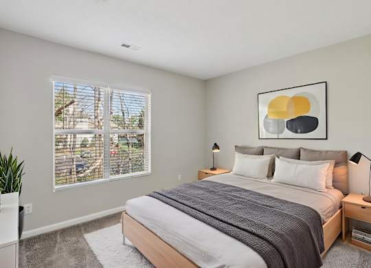 A bedroom with a large bed and a painting on the wall.