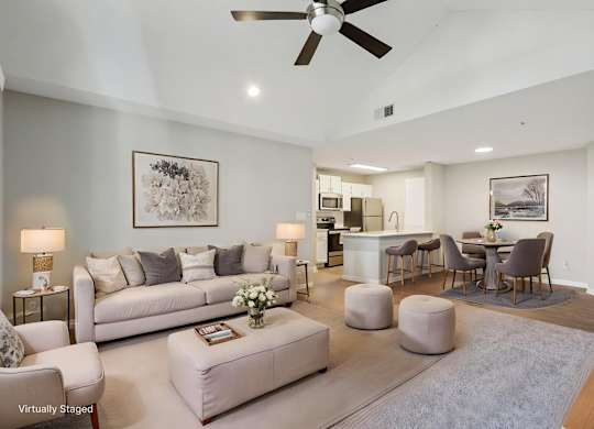 A living room with a white couch and a ceiling fan.