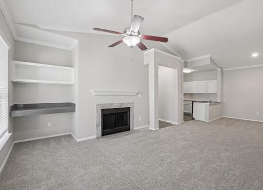 A living room with a fireplace and a ceiling fan.