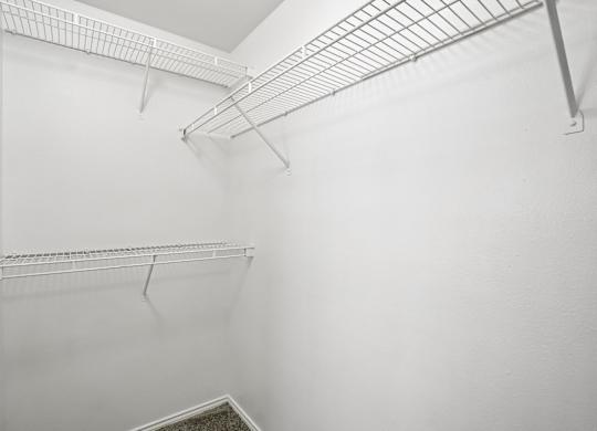 A white wall with a metal shelf on it.