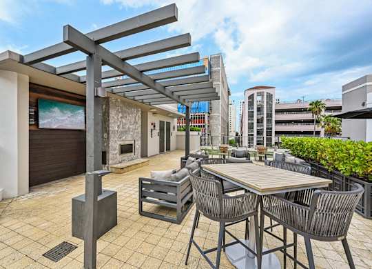 A patio with a table and chairs under a pergola.