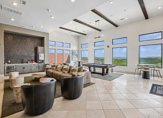A living room with a pool table and a view of the outdoors.