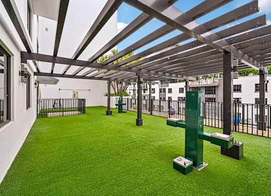 A patio with a green lawn and a white building in the background.