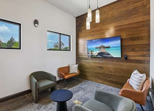 A living room with a flat screen TV mounted on a wooden wall.
