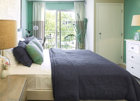 a bedroom with green walls and a bed with a gray blanket