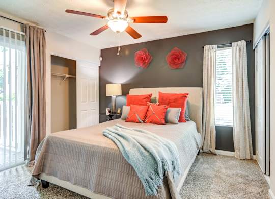 Pet Friendly Apartments in Roswell, GA - 2200 Big Creek Apartments - bedroom with furniture, beautiful window, and ceiling fan