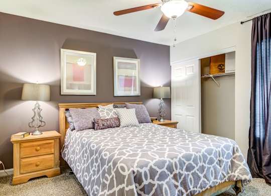 Pet Friendly Apartments in Roswell, GA - 2200 Big Creek Apartments -  Bedroom with large bed and ceiling fan
