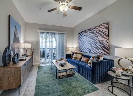 a living room with a blue couch and a ceiling fan