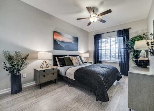 an empty bedroom with a ceiling fan and a bed