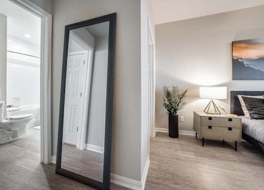 a mirror in a bedroom with a bed and a bathroom
