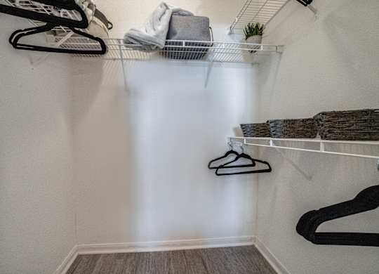 a walk in closet with shelves and shoes on the wall