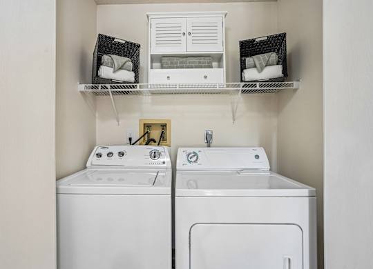 A white washing machine and dryer in a small laundry room.