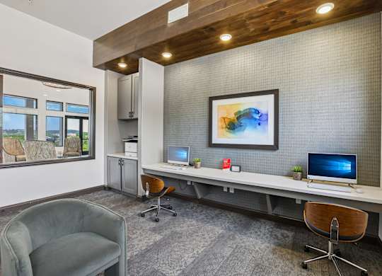 A modern office with a wooden ceiling and a large window overlooking a field.