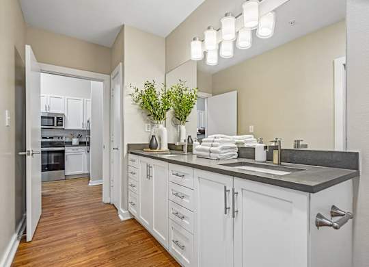 A kitchen with white cabinets and a grey counter top.