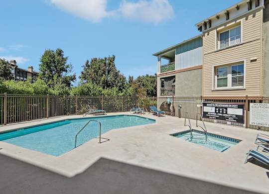 A swimming pool in a residential area with a caution sign.