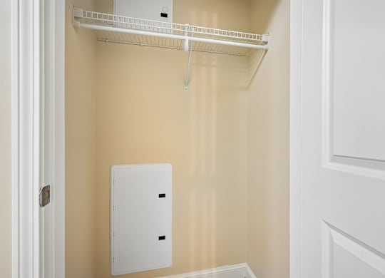 A white metal shelf is mounted on a wall.