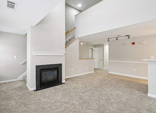 A living room with a fireplace and a staircase.