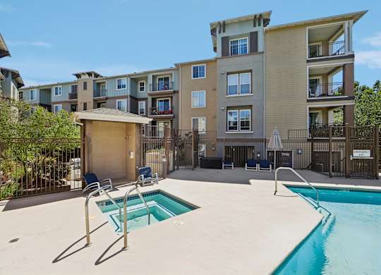 A swimming pool in a residential area with a small pavilion.