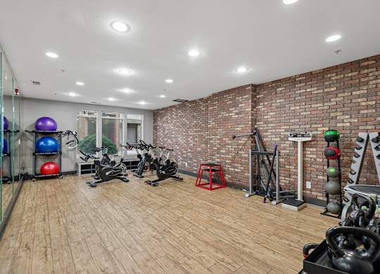 A gym with a brick wall and wooden floors.