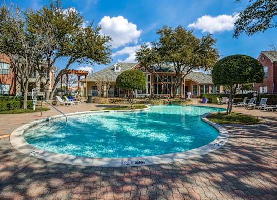 Plano TX Apartments for Rent - Carrington Park - Sparkling Pool Surrounded By Trees and Lounge Chairs